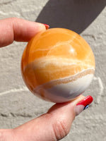 Load image into Gallery viewer, Large Orange Calcite sphere
